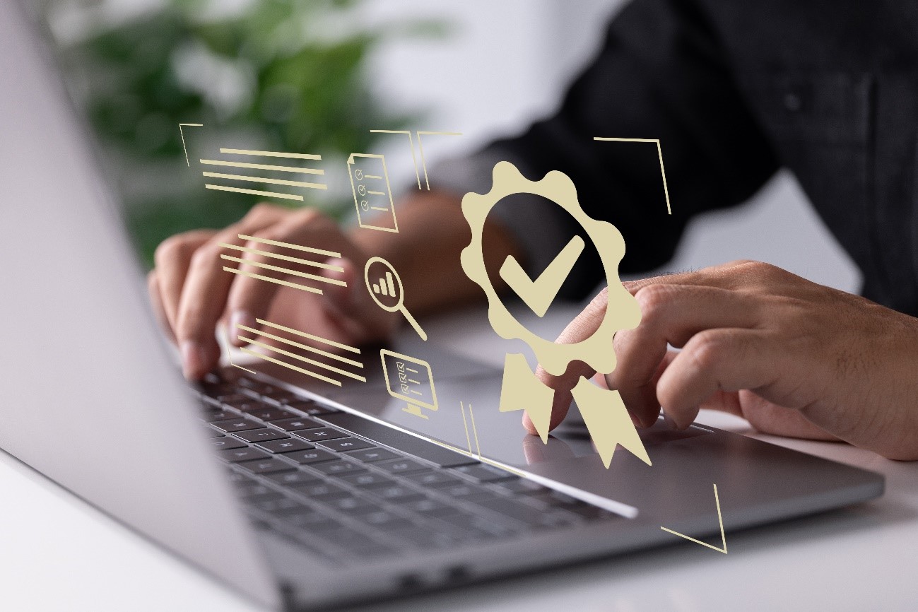 Masp em qualidade: saiba como aplicar a metodologia em sua empresa. Imagem das mãos de um homem mexendo em um notebook, que mostra um símbolo de qualidade.